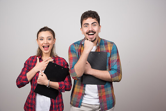 young-happy-couple-holding-clipboards-smiling.jpg  